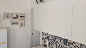 A small kitchen with a sink, wooden countertop, and a decorative ship model on the wall. - AB_Apartment  (Marina di Ragusa)