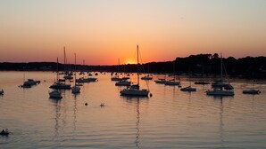 Un puerto deportivo con varias embarcaciones fonqueadas en aguas tranquilas al atardecer.