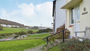 Ein Gebäude mit weißer Fassade, einer roten Markise und einem Schild mit der Aufschrift 'Drift Cottage'.