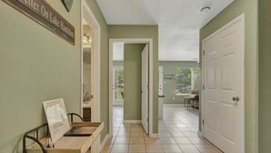 A hallway with a wooden bench, a door, and a view of a patio area. - Lake Front Condo with Boat Slip / Unit 9 / Close to Bathhouse Row and Oaklawn! (Hot Springs)