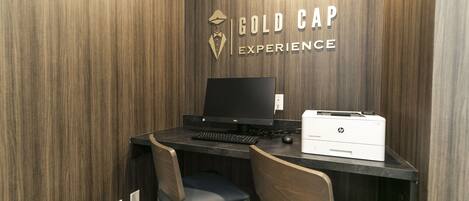 A workspace with a desk, two chairs, a computer, and an HP printer.