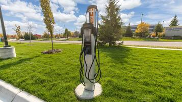 A charging station in a grassy area with a building in the background.