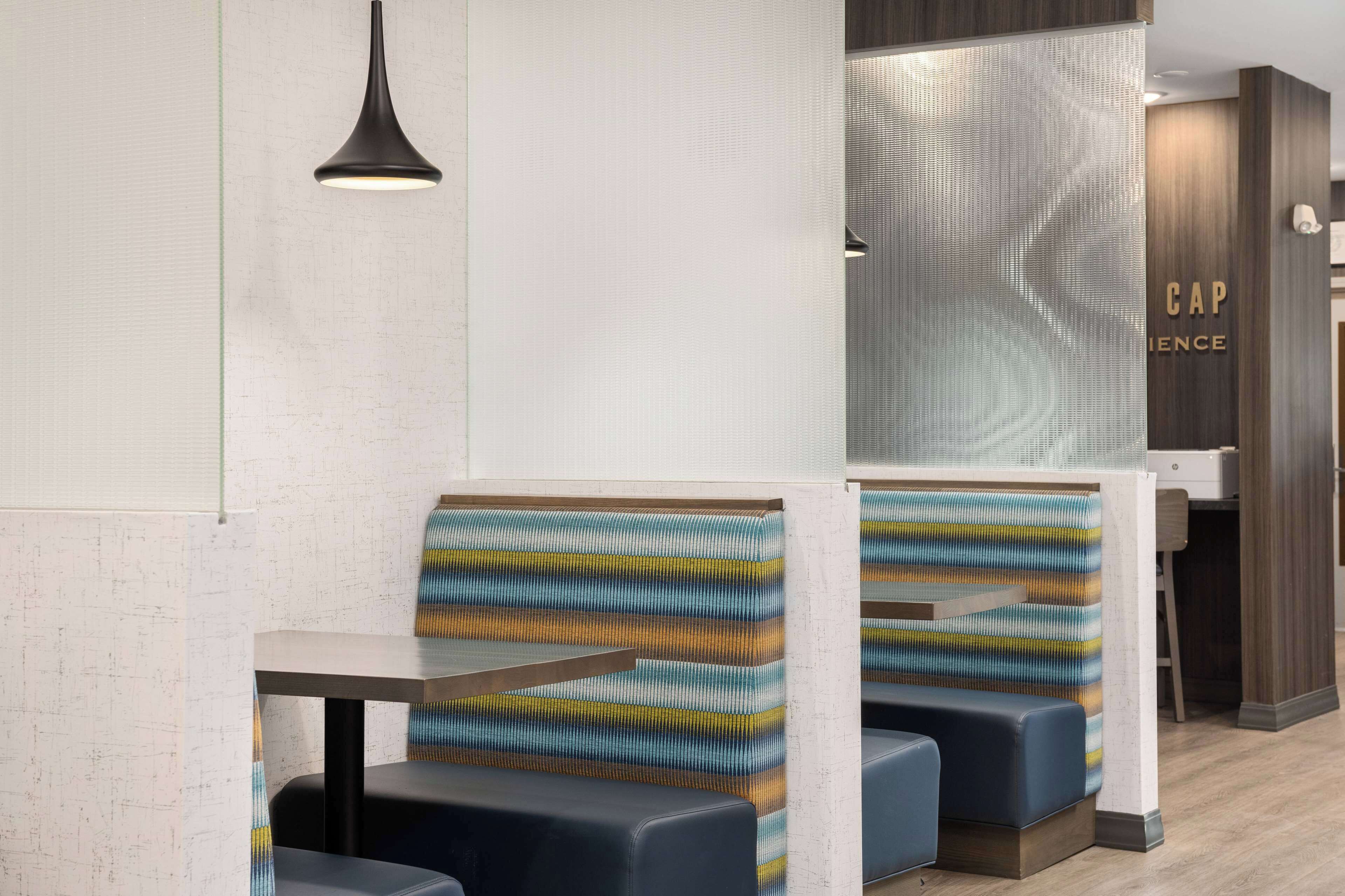 A modern restaurant interior with booth seating and a counter.