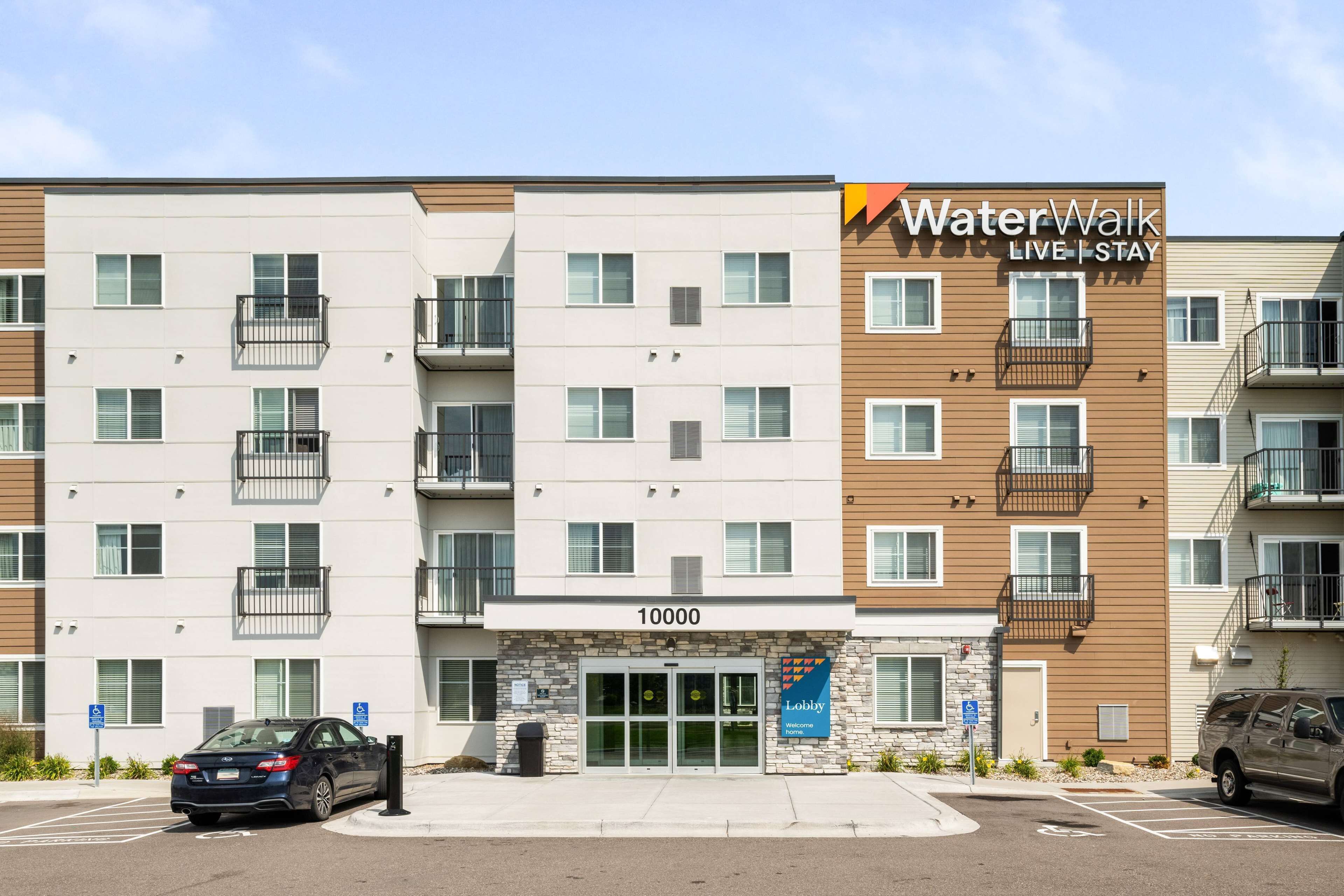 Un condominio a più piani con un cartello che recita 'WaterWalk LIVE I STAY'.