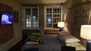 Two beds, a television, and a lamp are featured in this cozy space.