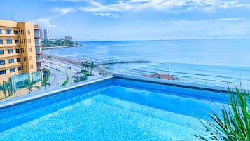 Una piscina al aire libre, sillones reclinables de piscina