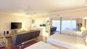 A hotel room with a bed, a sofa, a TV, a desk, and a balcony with a view. - Luxury Ocean Marina View Studio World Famous Ilikai NO RESORT FEES! FREE WIFI (Honolulu)