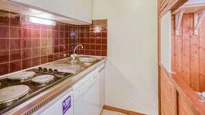 A compact kitchen with a stove, sink, and dishwasher. - Le Borsat (Val Claret) by Interhome (Tignes)