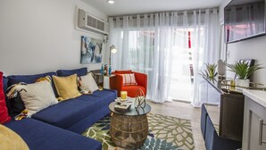 A modern living room with a blue sofa, a red armchair, and a round coffee table. - Riverside Tiny Home Retreat  (Hampton)
