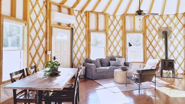 Un interior acogedor con techo de madera, un sofá, una mesa de comedor y una chimenea.