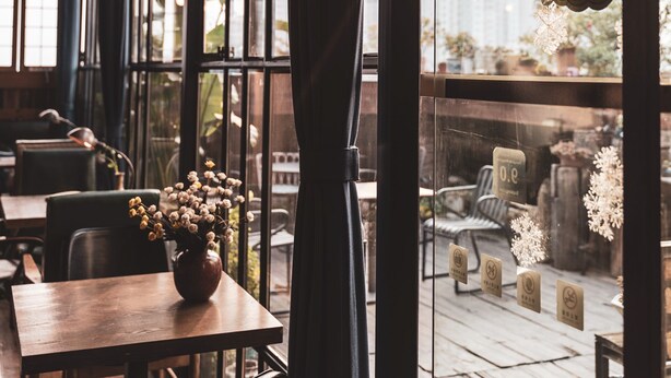 A cozy restaurant interior with large windows, wooden tables, and chairs. - MinGuo Life Zhangjiajie (Zhangjiajie)