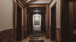 A hallway with wooden doors, a tiled floor, and a framed picture on the wall. - MinGuo Life Zhangjiajie (Zhangjiajie)