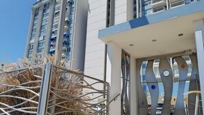 Een modern gebouw met een metalen hek en een klein raam.