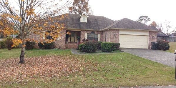 A two-story brick house with a garage, surrounded by a lawn and trees with autumn leaves. - Welcome to Polly's Place (Rockwell)