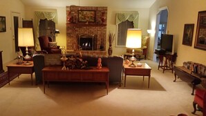 A cozy living room with a fireplace, a comfortable sofa, and a television. - Welcome to Polly's Place (Rockwell)