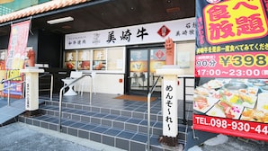 A restaurant entrance with a signboard displaying the name and menu. - Sakuraya (Okinawa)