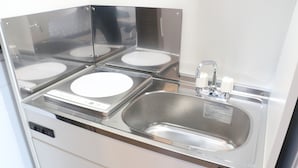 A stainless steel kitchen with four sinks, a built-in dishwasher, and a faucet. - Sakuraya (Okinawa)