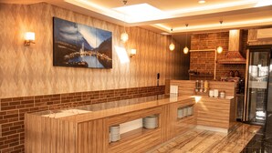 Una cocina moderna con una isla de madera, un cuadro grande y un salpicadero de ladrillo.