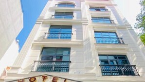 Entrada de un hotel con un llamativo letrero que dice 'HOTEL' sobre las puertas.