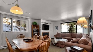 A cozy living room with a wooden dining table, a brown sofa, and a fireplace. - Great Weekend Destination-Between Snowbird & Alta, Hot Tub, BBQ, Free Parking, Free Ski Rental (Alta)