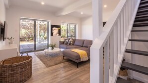 A modern living room with a grey sofa, a coffee table, and a wicker basket. - Coastal home in Gracetown - relaxing! (Gracetown)