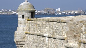 A stone fortification with a dome structure, overlooking a body of water and a cityscape in the background. - Chalet 100 m from the little sea of Gâvres (Riantec)