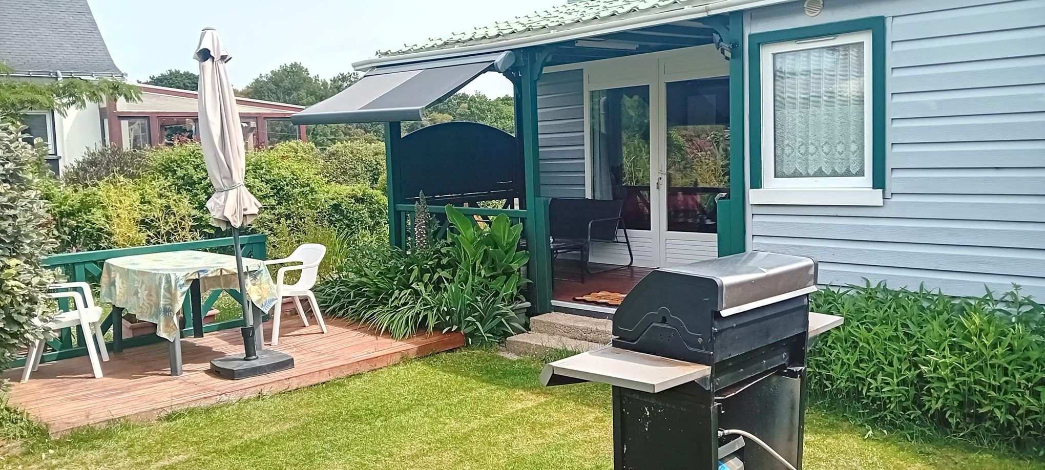 A patio with a grill, outdoor seating, and a covered area.