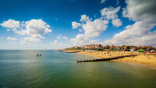 A coastal beach scene with a pier extending into the water, a sandy beach, and buildings in the background. - Charming 3 bedroom cottage in heart of Southwold (Southwold)