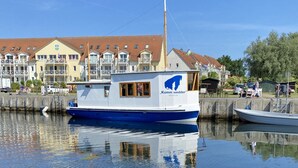 Un bateau était amarré dans une marina, avec une rangée de maisons en arrière-plan.