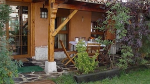 A rustic outdoor seating area with a stone floor, wooden furniture, and a pergola structure. - Classic Double Room: Double studio, with capacity for two people. (Olmedo)