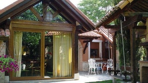 A wooden cottage with a glass door and a patio area with outdoor furniture. - Classic Double Room: Double studio, with capacity for two people. (Olmedo)