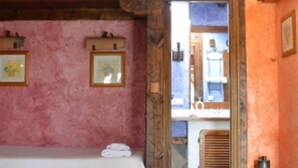 A room with pink walls, a bed, a mirror, and a window. - Basic Triple Room: Private entrance and porch (Olmedo)