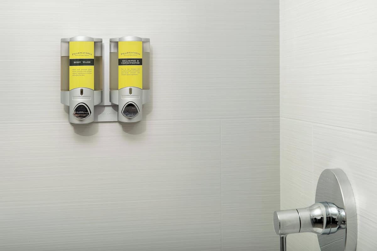 A wall-mounted hand dryer and a towel dispenser in a bathroom.