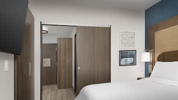 Een hotelkamer met een bed, een kledingkast, een badkamer en een aan de muur hangend kunstwerk.