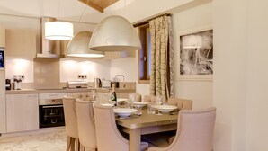 Una cocina moderna con zona de comedor. Incluye estufa, horno y una mesa de comedor con sillas.