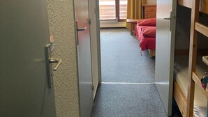 Une chambre d’hôtel avec un lit, une table de chevet en bois et une fenêtre avec des rideaux.
