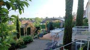 Un jardin agrémenté d’un belvédère, d’un espace détente et de grands arbres.
