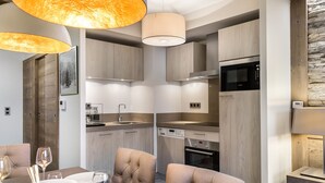 A modern kitchen with wooden cabinets, a built-in oven, and a microwave. - Charming apartment in Courchevel Village, near slopes, WIFI, parking included (Courchevel 1550)