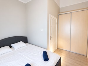 A bedroom with a bed, a wardrobe, and a door.