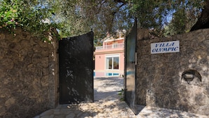 Un chemin de pierre mène à une villa portant l’inscription « Villa Olympic ».