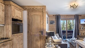 L'intérieur d'un chalet en bois comprend une cuisine, un coin repas et un espace salon confortable.