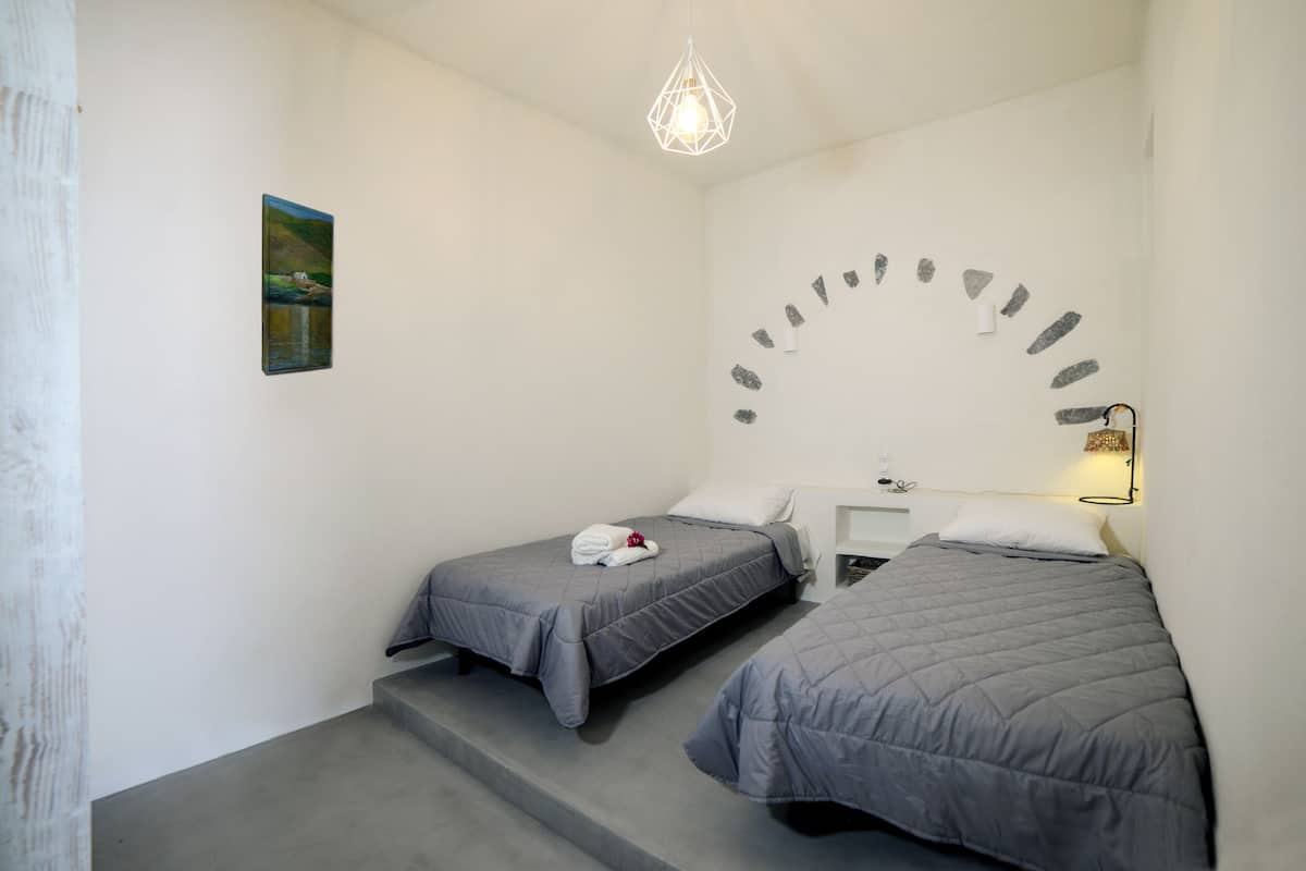 Ein Zimmer mit zwei Betten, einem Schreibtisch und einer außergewöhnlichen Wanddekoration.