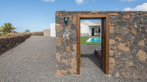 Eine Steinsäule mit einer Holztür, die zu einem Poolbereich führt.