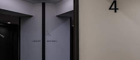 A hotel room with a blue sofa, a door labeled '4F', and a wall with the number '4'.