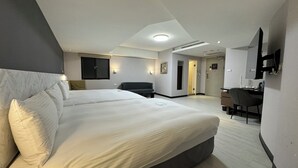Une chambre d’hôtel moderne équipée d’un grand lit, d’un bureau, d’une chaise et d’un téléviseur.