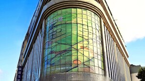 Un hôtel moderne à la façade incurvée, doté de grandes fenêtres et d’une enseigne bien visible indiquant qu’il s’agit d’un hôtel.