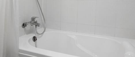 A modern bathroom with a white bathtub, a shower head, and a curtain.