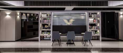 Una biblioteca moderna con estanterías, una zona de exhibición central y un área de descanso.