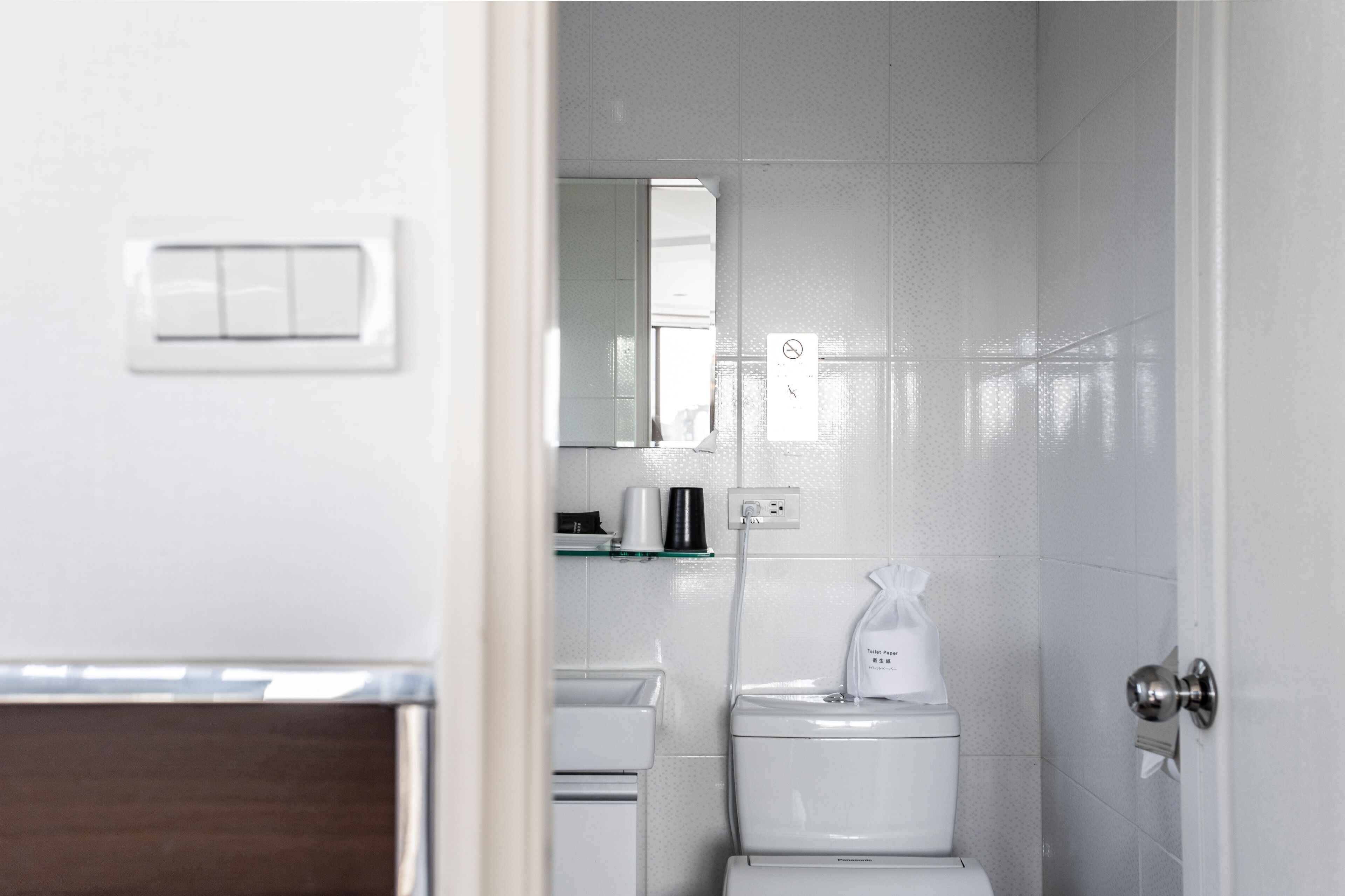 Un baño pequeño y limpio, con inodoro, lavamanos y espejo.