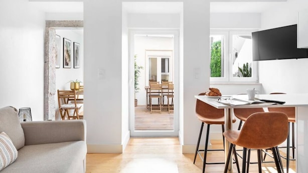 Un espacio habitable moderno con sofá, comedor y cocina.